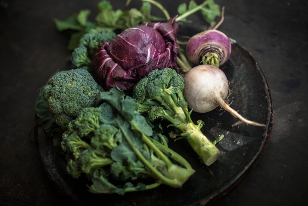 Cruciferous Vegetables -cabbage and broccoli in a black plate, dark background